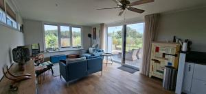 Una sala de estar con un sofá azul y una mesa. en Charmant Chalet met privétuin in Someren - VP063, en Someren