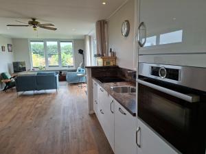 una cocina con fregadero y estufa horno superior en Charmant Chalet met privétuin in Someren - VP063, en Someren 12 fotos más
