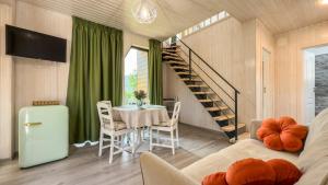 a dining room with a table and a spiral staircase at A-Frame Valley in Buşteni