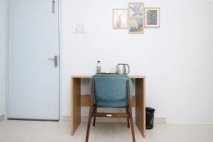 a blue chair sitting at a desk in a room at Urban Suites Silpukhuri in Guwahati