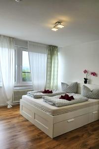 a large white bed in a room with a window at Gemütliche Ferienwohnung mit großer Dachterasse in Offenburg