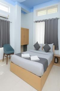 a bedroom with a large bed and a chair at Urban Suites Silpukhuri in Guwahati +27 photos