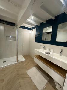 un bagno con due lavandini e una doccia di Séjournez face au Château Royal de Blois a Blois Altre 10 foto