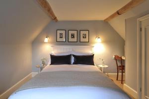 a bedroom with a bed with two pictures on the wall at Jasmine Cottage, Upper Slaughter, Cotswolds in Cheltenham