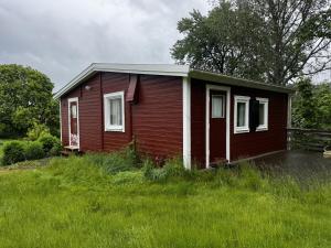 une petite maison au milieu d'un champ dans l'établissement Cozy wilderness cabin at Kynnefjäll close to lake SE09081, à Hällevadsholm