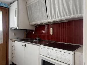 - une cuisine avec des appareils blancs et du carrelage rouge dans l'établissement Cozy wilderness cabin at Kynnefjäll close to lake SE09081, à Hällevadsholm 5 autres photos
