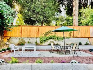eine Terrasse mit Tisch und Stühlen und einem Sonnenschirm in der Unterkunft Cozy 1 Bedroom Mini Apartment 10 Mins to SeaTac Airport in Seattle