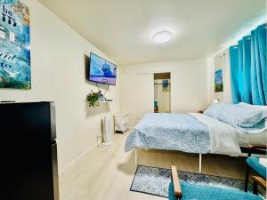 ein Schlafzimmer mit einem Bett und einem Fernseher an der Wand in der Unterkunft Cozy 1 Bedroom Mini Apartment 10 Mins to SeaTac Airport in Seattle