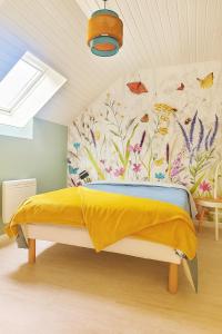 1 dormitorio con cama amarilla y pared de flores en Gîte Youna - Nature et charme breton entre Lizio et Josselin, en Lizio