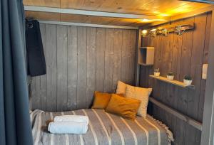 a small bed in a room with wood paneling at Le Corsaire in Angers +2 photos
