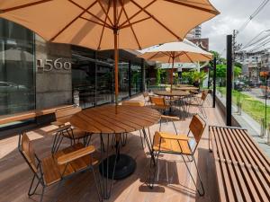 a group of tables and chairs with umbrellas on a sidewalk at Mercure Belem Boulevard in Belém