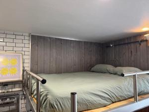 a bed in a room with wood paneling at Le Corsaire in Angers