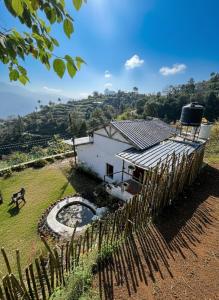 a white house with a fence in front of it at Arameh-A Boutique Orchard Retreat Near Kasauli in Rājgarh