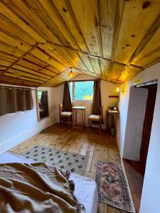 a room with a bed and a wooden ceiling at Arameh-A Boutique Orchard Retreat Near Kasauli in Rājgarh