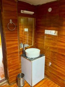a bathroom with a sink and a toilet in a room at Arameh-A Boutique Orchard Retreat Near Kasauli in Rājgarh
