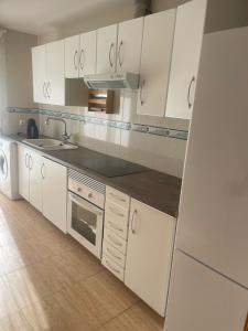 Una cocina con gabinetes blancos y un fregadero. en Cuencaloft Villa Paraíso, en Carrascosa del Campo