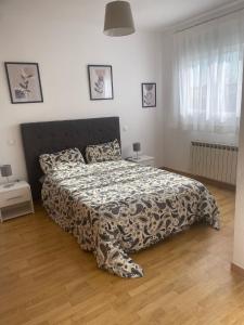 a bedroom with a bed with a black and white comforter at Cuencaloft Villa Paraíso in Carrascosa del Campo