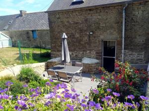 una mesa con sombrilla frente a un edificio de ladrillo en Gîte Youna - Nature et charme breton entre Lizio et Josselin, en Lizio 9 fotos más