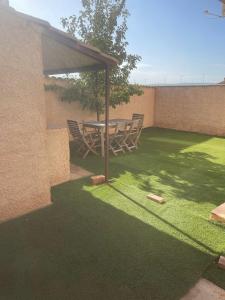 a picnic table and chairs under a pavilion on a lawn at Cuencaloft Villa Paraíso in Carrascosa del Campo