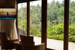 Habitación con vistas a un balcón con sillas. en The Allure Ubud Villas & Spa crafted by freshWater Asia, en Ubud
