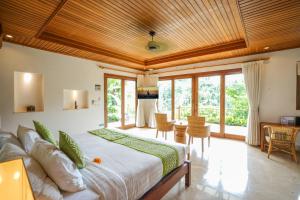 a bedroom with a large bed in a room with windows at The Allure Ubud Villas & Spa crafted by freshWater Asia in Ubud +53 photos
