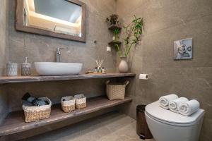 a bathroom with a sink and a toilet at Rosmari Hotel in Archangelos +31 photos