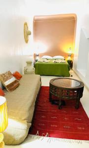 um quarto com 2 camas e uma mesa de centro em Riad Dar Lilas em Marraquexe