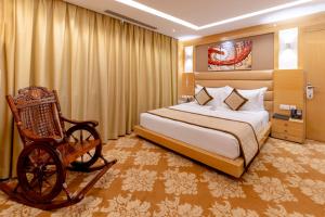a bedroom with a bed and a chair in it at Hotel Patliputra Continental in Patna +61 photos