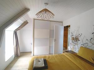 Un dormitorio con una cama y una lámpara de araña en Gîte Youna - Nature et charme breton entre Lizio et Josselin, en Lizio