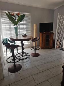 a living room with a table and chairs and a television at Valley Cottage in Kenton on Sea