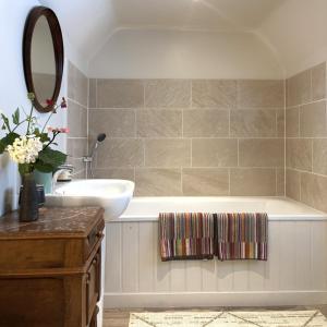 a bathroom with a tub and a sink and a mirror at Woolmarket House in Kings Lynn +20 photos