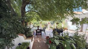 Un patio con una mesa y sillas y un árbol. en Mshome La Noble, en Monachil