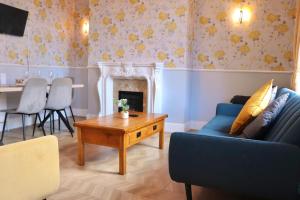 ein Wohnzimmer mit einer blauen Couch und einem Kamin in der Unterkunft Comfortable 2 Bed Property with garden - Parking in Hunslet