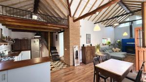 Una cocina y una sala de estar con mesa y sillas. en Mshome La Noble, en Monachil