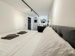 a white bedroom with a bed and a couch at Cave-Salzburg in Salzburg