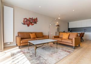a living room with two couches and a table at Acropolis - Luxury Appartments I Hotelservice and parking in Middelkerke