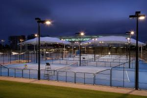 a group of tennis courts at night with lights at Smart Suites Self Check-in Apartments - W Freney in Brisbane
