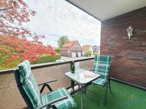 a patio with two chairs and a table on a balcony at Auszeit im Haus Elbe Whg.6 in mitten von Döse, 800m bis zum Strand in Cuxhaven