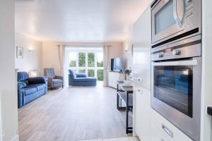 サンダースフットにあるTy Kered - 2 Bed Townhouse - Saundersfootのソファとテレビのあるリビングルーム