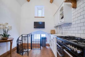 a kitchen with white walls and a black stove top oven at Caldey View - 3 Bed - Hot Tub - Penally - Tenby in Penally