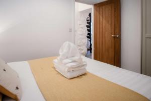 a pile of towels sitting on top of a bed at Caldey View - 3 Bed - Hot Tub - Penally - Tenby in Penally +46 photos