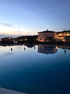 a large pool of water in front of a building at Splendida vista mozzafiato Costa Rossa Sardegna in Isola Rossa
