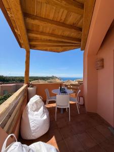 a room with a balcony with a table and chairs at Splendida vista mozzafiato Costa Rossa Sardegna in Isola Rossa