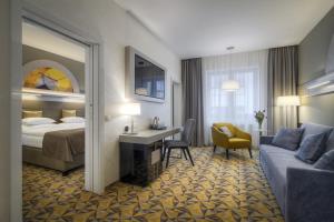 Habitación de hotel con cama, escritorio y sofá en Hotel Essence, en Praga 33 fotos más