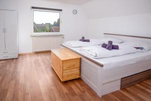 a bedroom with a large white bed and a window at Daniels Huus in Hinte