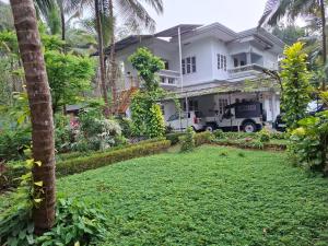 a house with a lawn in front of it at greenview homestay Mayyil in Parassinikadavu