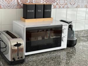un microondas en una encimera junto a un horno tostador en Vivienda Vacacional Los Campones, en Berrón