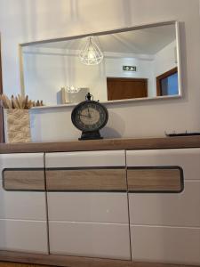 un reloj sentado en la parte superior de un tocador con un espejo en Vivienda Vacacional Los Campones, en Berrón 21 fotos más