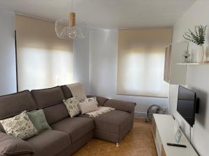 Una sala de estar con un sofá y un televisor. en Vivienda Vacacional Los Campones, en Berrón