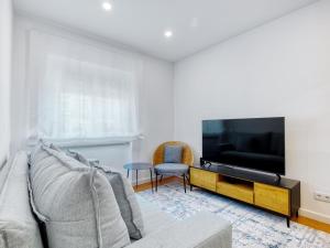a living room with a couch and a flat screen tv at Vita Portucale ! Almada Trendy Retreat in Almada